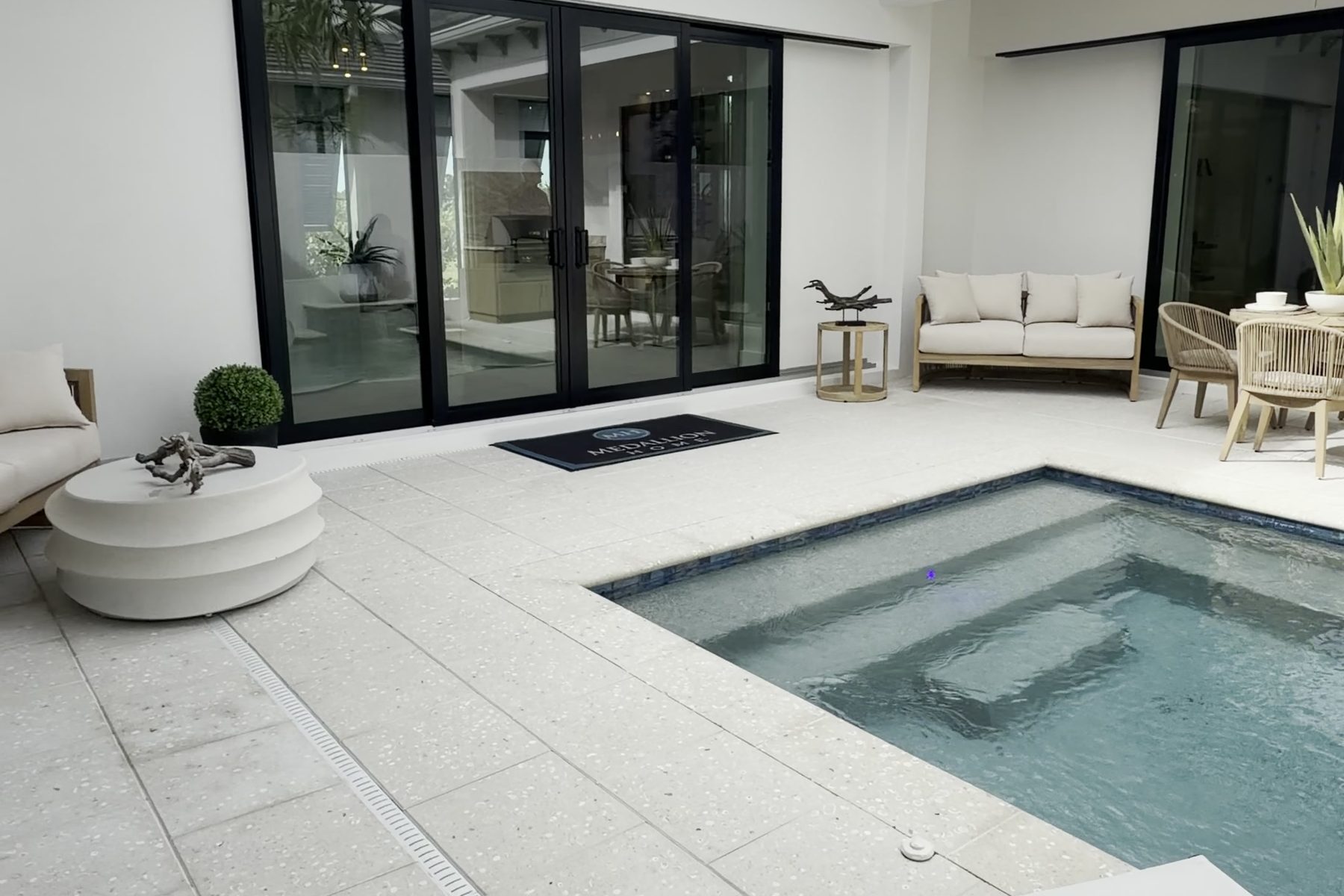 The courtyard pool inside the Silver Palm model at Aqua, with sliding glass doors on two sides.