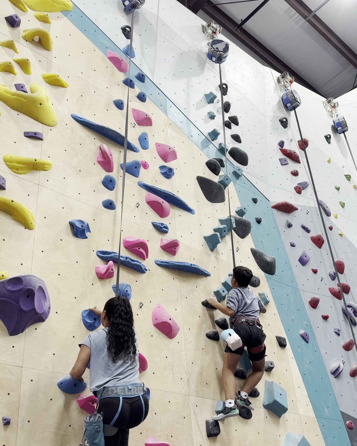 Sekina and one of her sons climbing side by side on auto belay walls.